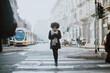 © oneinchpunch - Beautiful girl with afro haircut walking on the street