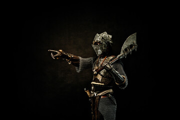 Wall Mural - Medieval fighter in armor, pointing a finger at a direction, in profile, an ax on his shoulder