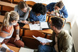 © BalanceFormCreative - College students taking a test in a classroom.Educational concept.