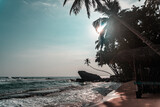 Fototapeta Fototapety z morzem do Twojej sypialni - Duża skała na tle palm i oceanu, tropikalne wybrzeże.