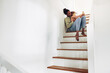 © Flamingo Images - Mom reading a story to her little girl on stairs at home