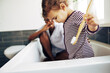 © Flamingo Images - Little girl with a toothbrush sitting with her mom in their bathroom