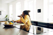 © Flamingo Images - Young mom looking after her daughter while working from home.