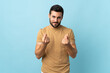 © luismolinero - Young handsome man with beard over isolated background making money gesture but is ruined
