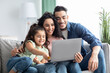 © Prostock-studio - Online Shopping. Happy Arabic Family Using Laptop And Credit Card At Home