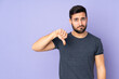 © luismolinero - Caucasian handsome man showing thumb down with negative expression over isolated purple background