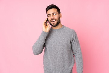 Poster - Caucasian handsome man over isolated background keeping a conversation with the mobile phone