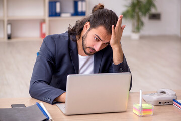 Young male employee working in the office