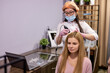 © alfa27 - head of young woman with thinning hair during the examination of the scalp and hair with a microscope, getting trcihology examination. cosmetologist and client in modern cabinet