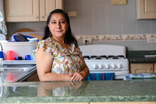 Proud Hispanic Woman Posing In Her Kitchen Clean-smiling Mom Standing In The Kitchen-woman In The Kitchen Not Cooking