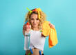 © alphaspirit - Blonde housewife splashs disinfectant to remove viruses and bacteria. Cyan background