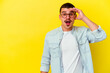 © Asier - Young caucasian cool man isolated on yellow background shouts loud, keeps eyes opened and hands tense.