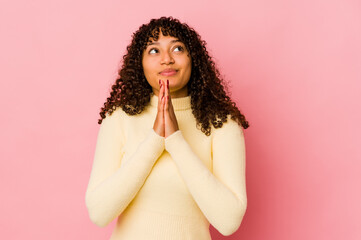 Young african american afro woman isolated holding hands in pray near mouth, feels confident.