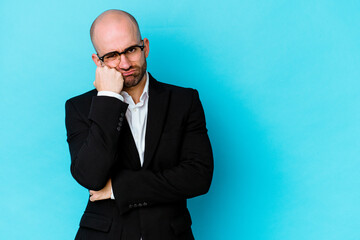 Young business caucasian bald man isolated on blue background who feels sad and pensive, looking at copy space.