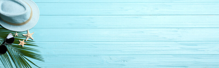 Beach accessories and space for text on light blue wooden background, flat lay. Banner design