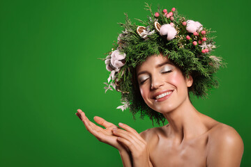 Wall Mural - Happy young woman wearing wreath on green background. Space for text