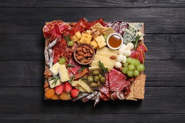 Wall Mural - Assorted appetizers served on black wooden table, top view