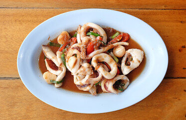 Canvas Print - Stir fried squid with shrimp paste on plate on table background.