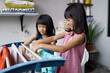 © Odua Images - two children having fun happy little girl to wash clothes and laughs in the laundry room