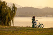 © 상혁 이 - A silhouette of a bicycle with a woman in the sunset overlooking the river.