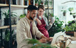© Halfpoint - Shop assistants with laptop working in potted plant store, small business concept.
