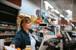 © Jacob Lund - Female cashier at grocery store