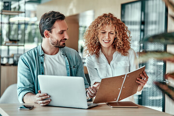 Wall Mural - Disappointed businesswoman looking in notebook with coworker in cafe