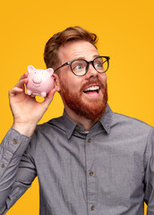 Wall Mural - Excited man checking savings in money box