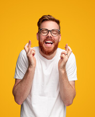 Cheerful man crossing fingers and making wish