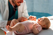 Pediatrician examining little baby to prevent diseases