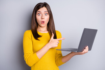 Wall Mural - Photo of impressed brunette nice lady hold point laptop wear yellow sweater isolated on grey color background
