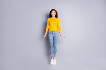 Canvas Print - Full size photo of optimistic brunette nice lady jump wear yellow sweater jeans sneakers isolated on grey color background