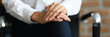 Woman in white blouse sit on chair with her hands folded together on her knees. Professional psychologist conduct session. Treatment of mental illness. Psychological conversation for treatment of