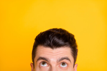 Poster - Cropped photo of impressed funny young man looking up empty space isolated yellow color background