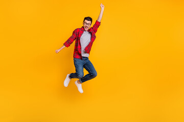 Sticker - Full size photo of young happy positive funky man in glasses jumping in victory isolated on yellow color background