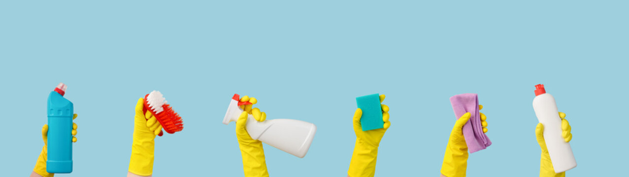 hands in rubber gloves with cleaning supplies banner with free space for text