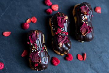 creamy chocolate eclair with edible flowers rose petals, romantic sweet dessert valentines day, wedding cake 