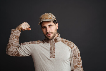 Wall Mural - Strong healthy military man showing biceps isolated