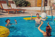 © Impact Photography - Friends playing volleyball at the swimming pool