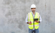 © NVB Stocker - Hispanic or Middle Eastern people. Portrait Of Construction Worker holding red radio and digital tablet isolate on gray cement background. Project engineer On Building Site.