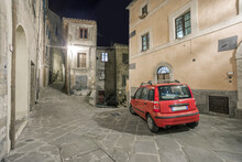Typical Red Car In A Narrow Street In An Italian Old Town At Night