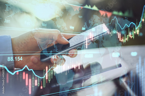 Obraz Dibond Online trading business concept with man hand using smartphone and transparent digital display with stock market graphs and diagram