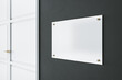 Light blank signage on dark wall before the entrance a room with white door. Mockup