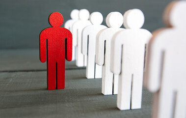 Two types of wooden persons on the wooden table: red and white