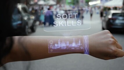 Female hand activates conceptual HUD holograms on smart bracelet with text Soft Skills. Unrecognizable woman with holographic technology on a city street background