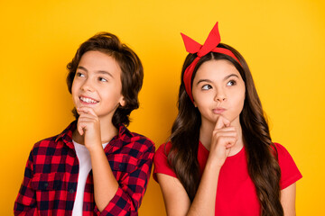 Wall Mural - Photo of thoughtful girl boy hand on chin look interested empty space imagine isolated on yellow color background