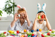 © Angelov - Easter concept. Grandmother with granddaughter are holding Easter eggs at home