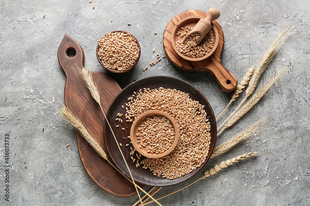 Bowls with wheat grains on grunge background