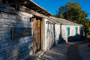 Wall Mural - Stone houses of traditional architecture and cobble-stone narrow street in Papigo in Epirus, Greece