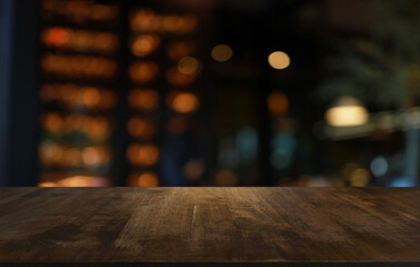 Poster - Empty wooden table in front of abstract blurred background of coffee shop . can be used for display or montage your products.Mock up for display of product